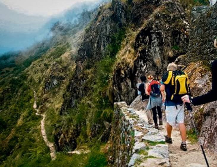 short inca trail 2 days Andean Top with travelers walking along the lush mountain path toward Machu Picchu