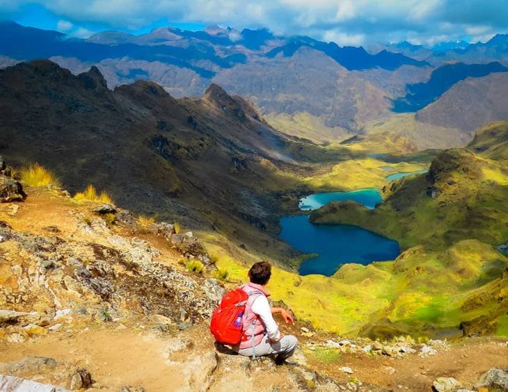 Lares trek to Machu Picchu – Andean Top hiker resting with panoramic view of lakes and mountains