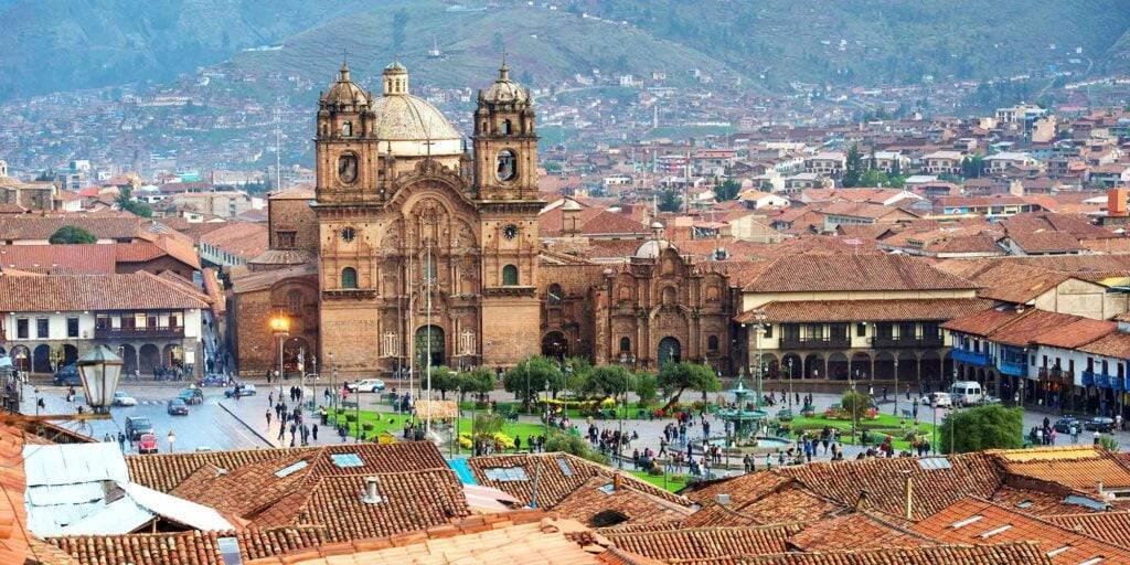 Colonial buildings and native trees in Cusco’s main square during the Cusco city tour half day