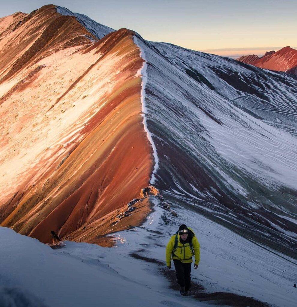 Tourist standing on a snowy trail at Rainbow Mountain