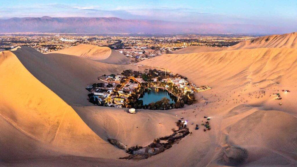 Panoramic view of the Huacachina Oasis surrounded by sand dunes