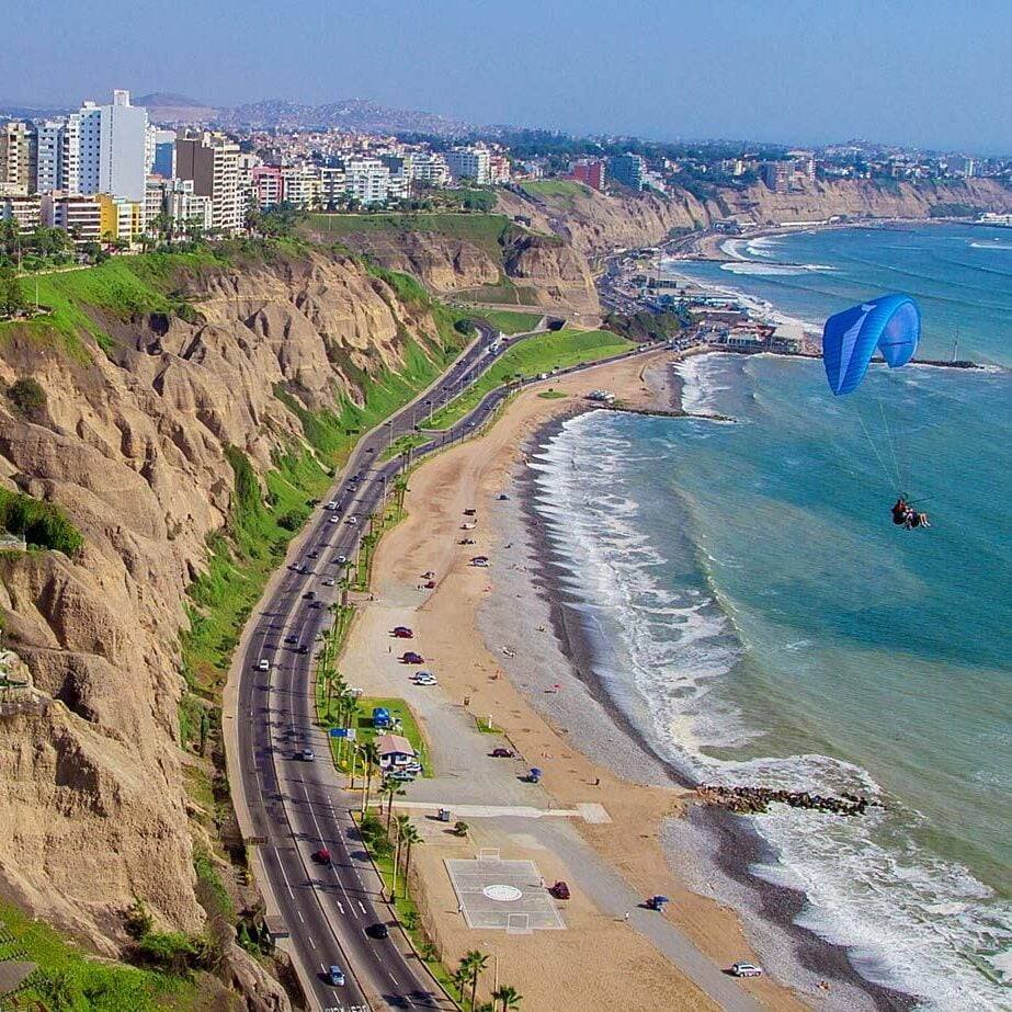 Paragliders flying above the coastline and beaches in Miraflores, Lima