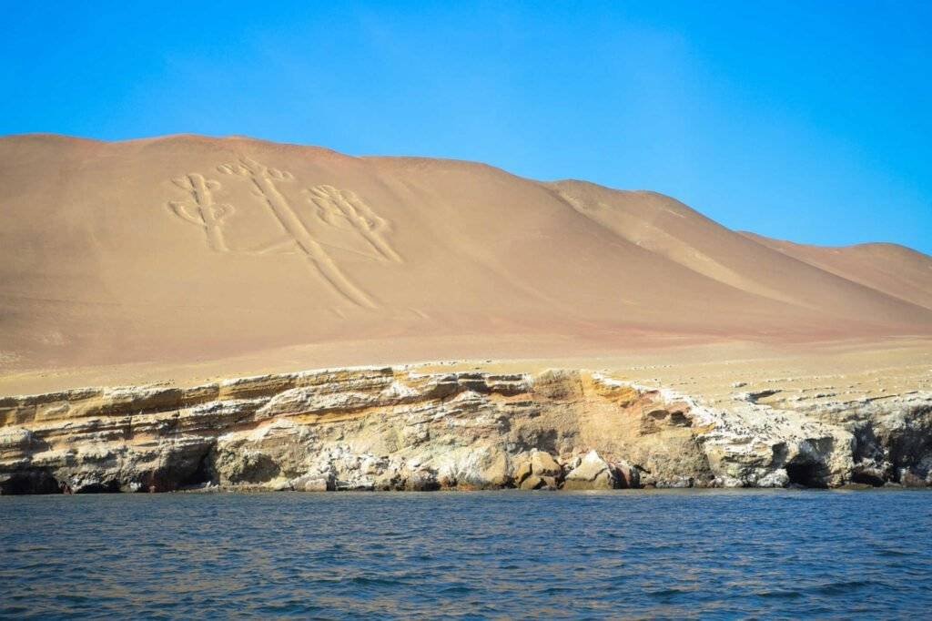 The mysterious Candelabro geoglyph carved into the sandy hills of Paracas as seen from a boat
