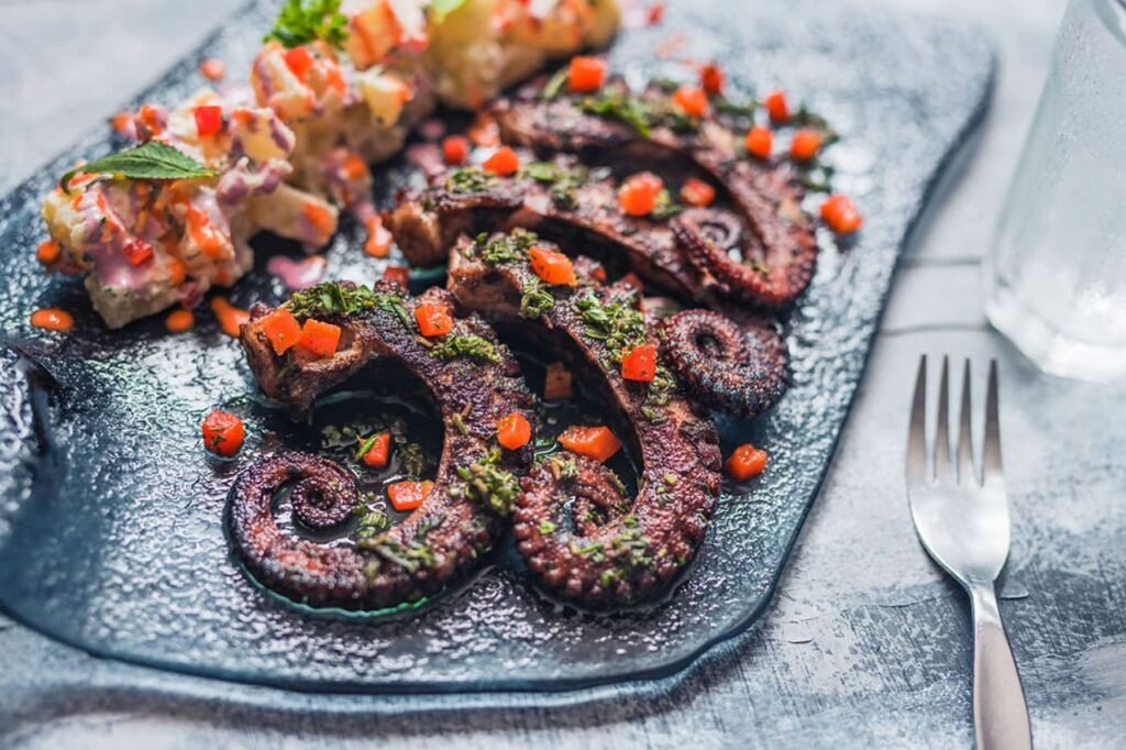 Gastronomic Tour Lima – Grilled octopus served with fresh herbs and sauce