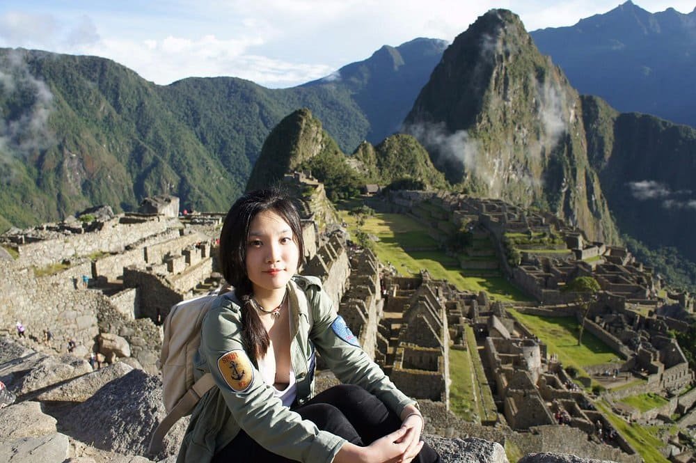 Inca trail Machu Picchu Titicaca – traveler sitting on a rock overlooking Machu Picchu